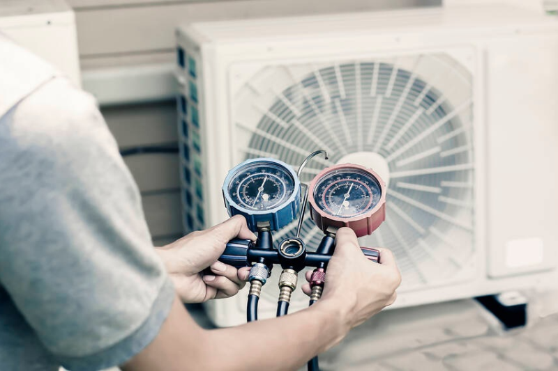 What are the signs of a refrigerant leak in an AC unit